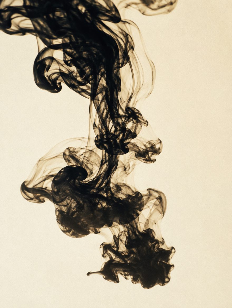 Black ink dispersing in water against an ivory background